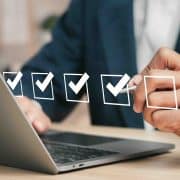 Checklist concept. Businessman using laptop. Checking mark on checkboxes.